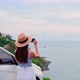 Young woman traveler taking a photo at the beautiful sea view with her car - VideoHive Item for Sale