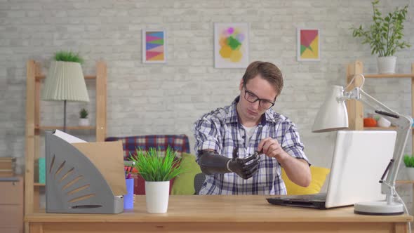 Young Man Repairing with a Screwdriver Cyber Prosthetic Hand