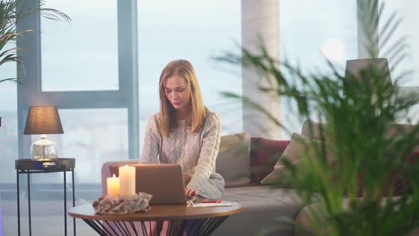 Young Woman Using Laptop While Sitting on Comfy Couch