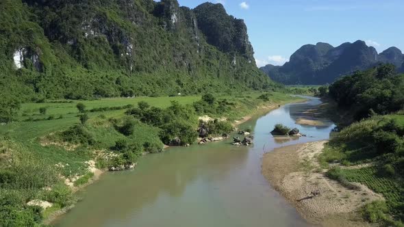 Nice Narrow River Flows Across Highland Valley Among Hills