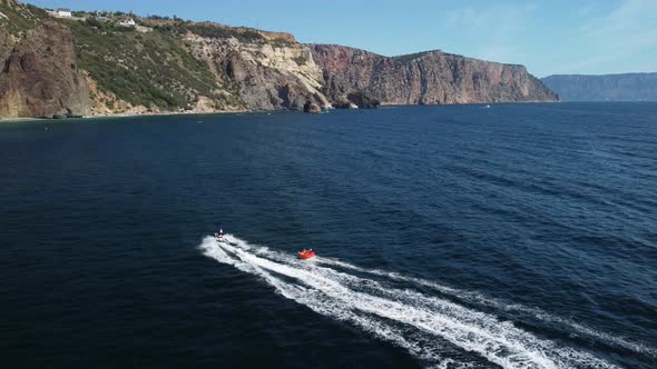 Happy People Swim on Air Mattress Behind a High Speed Water Bike