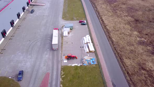 Truck is Driving to Logistics Center. Aerial Shot of Industrial Warehouse Loading Dock where Many Tr