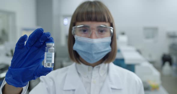 Portrait of Female Scientist in Protective Mask and Googles Looking To Camera