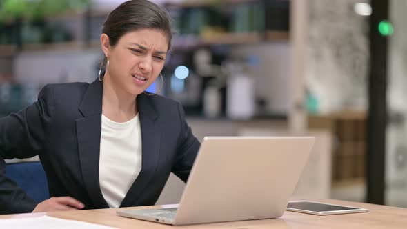 Tired Indian Businesswoman with Laptop Having Back Pain in Cafe 