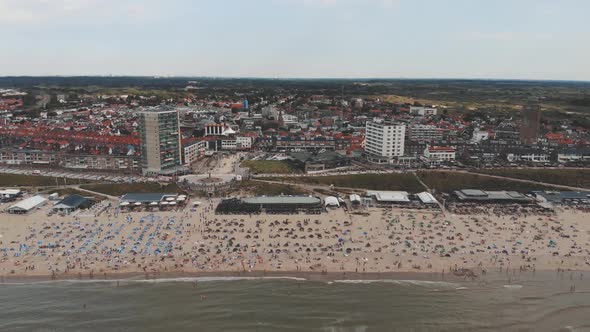 Aerial footage revealing a crowded beach along a North Sea city shore of Zandoort, Netherlands.