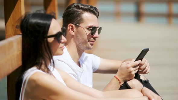 Picture of a Joyful Couple Using Smartphones in the Park