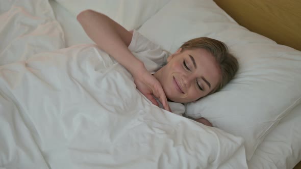 Attractive Young Woman Waking Up and Getting Out of Bed 