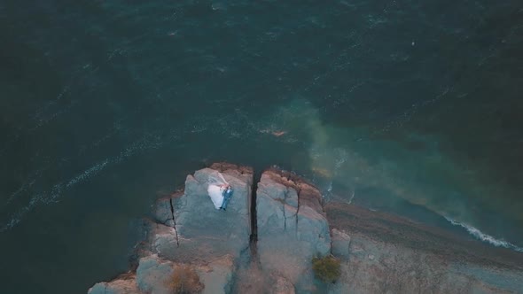 Wedding Newlyweds Couple Are Lying on a Mountainside By the Sea. Aerial Shot