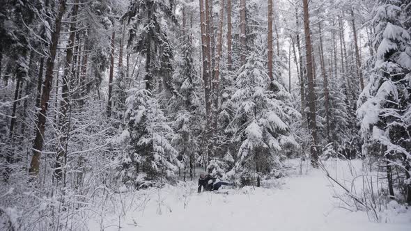 Man in a Jacket Runs in Winter Forest Slips Falls and Snow Falls on Him