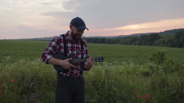 Smiled Man Starts to Play on Small Guitar