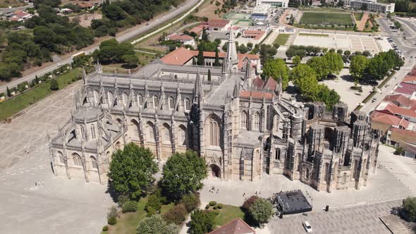 Cinematic birds eye view overlooking at the front facade of historic gothic style Batalha monastery.