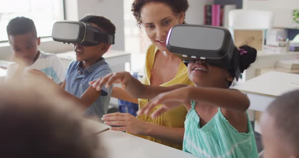 Video of happy caucasian female teacher with class of diverse pupils wearing vr headsets