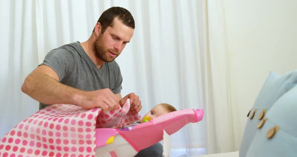 Father putting blanket on his baby 