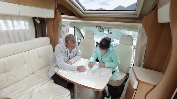 Couples in RV Camper Looking at the Local Map for the Trip