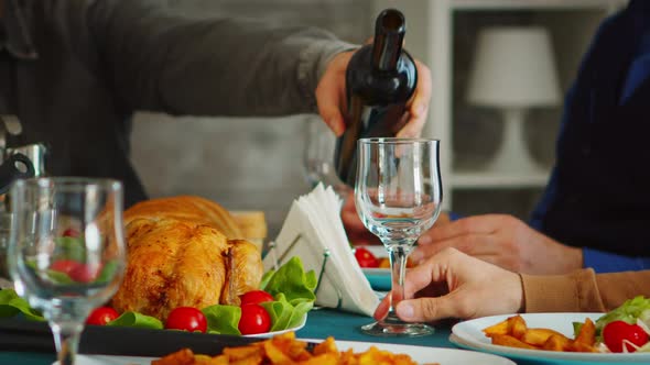 Close Up of Young Man Pouring Red Wine