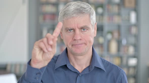 Portrait of Middle Aged Man Saying No with Finger Sign