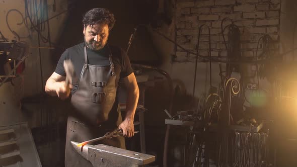 Brutal Man Working at the Forge with Metal. Slow Motion