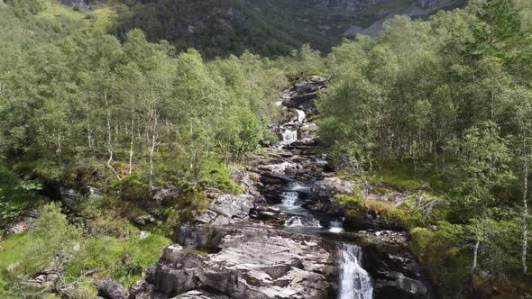 Flying very close to crispy clean river stream in between birch trees in Norway mountains - Leiro Ei