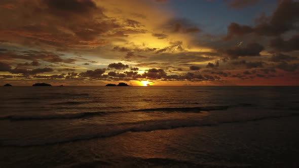 Aerial view of a calm tropical beach during orange sunset, Ko Chang, Thailand.