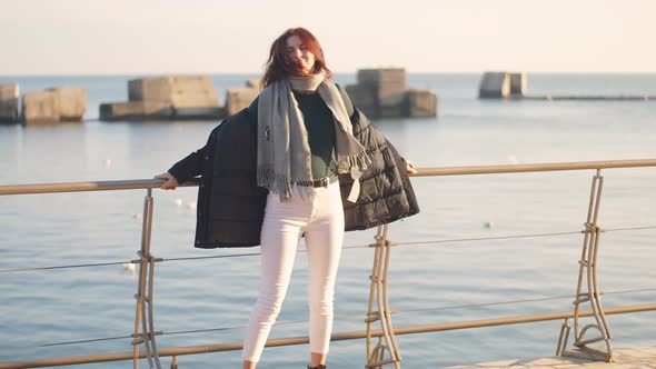Young Beautiful Woman Walks and Enjoys the Sea on a Warm Winter Day