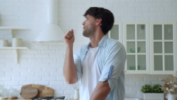 Man Singing Song Into Whisk, Cooking in Kitchen, Happy Male Listening To Music, Dancing