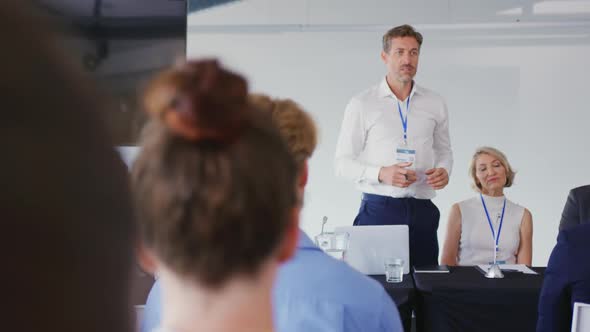 Speaker addressing the audience at a business conference