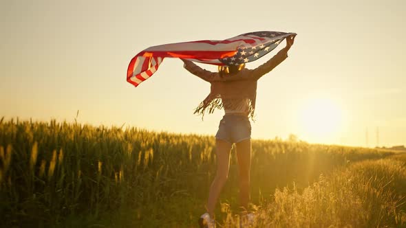 Patriot American Woman Holding Stars and Stripes Against Sky in Slow Motion