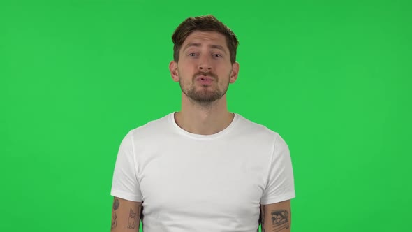 Portrait of Confident Guy Is Smiling and Showing Heart with Fingers Then Blowing Kiss. Green Screen