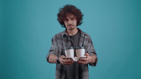 The Thoughtful and Cheerful Student with 2 Glasses of Coffee in His Hand Calls His Friends to Have