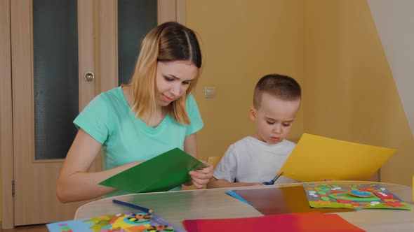 Mother Spending Time with Son Making Application Child Cutting Colored Paper