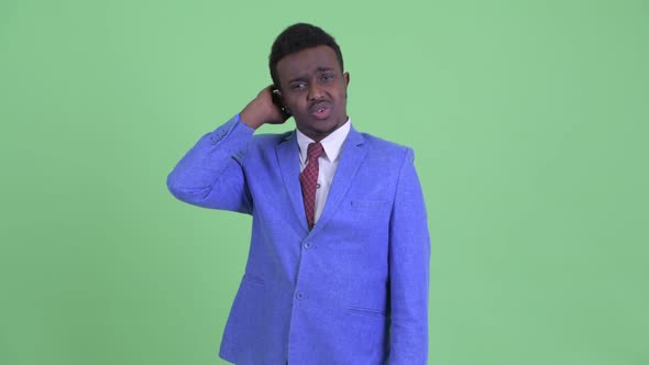 Confused Young African Businessman Scratching Head