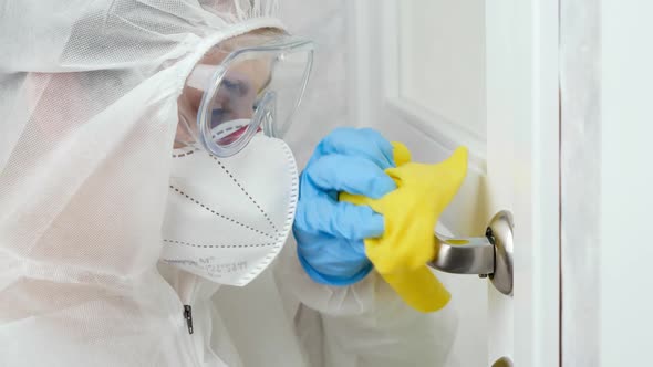 Portrait of Woman in Protective Suit Medical Mask and Gloves Desinfecting and Cleaning Door Handles