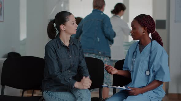 Woman Talking to Medical Assistant in Waiting Area