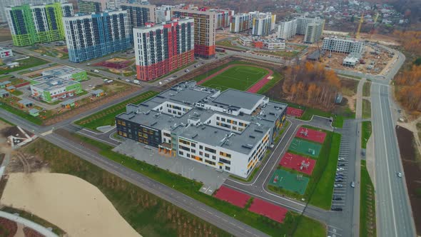 School Building with Grounds and Football Field in City