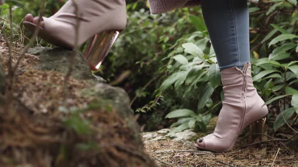 Stylish woman with pink shoes posing in jungle.