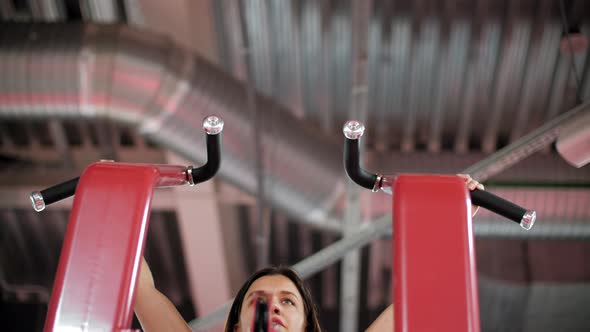 Sporty Young Woman Doing Pull Ups in Gym