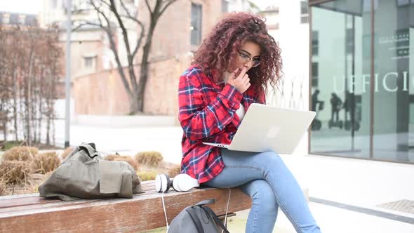 Young beautiful mixed race woman outdoor in the city using computer