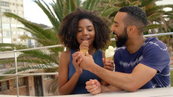 Couple eating ice cream cone at beach