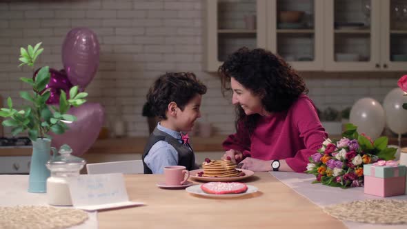 Mother Feeding Son with Homemade Pancakes