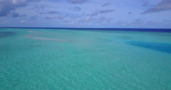 Tropical flying abstract shot of a white sandy paradise beach and aqua turquoise water background in