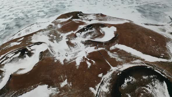 Flying over Skútustaðagígar Craters of Iceland, Snowy Volcanic Lands, Geology Site and Wetlands of L