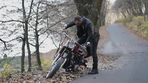 Handsome Biker Tries to Start Motorbike with Pedal and Handlebar