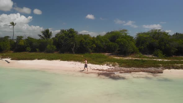 Man Walking on the Beach of Saouna Island in the Dominican Republic