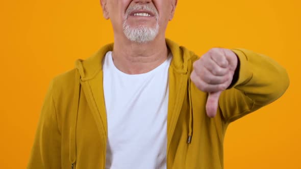 Displeased Elderly Man Showing Thumbs Down, Dislike Gesture, Disagreement Sign