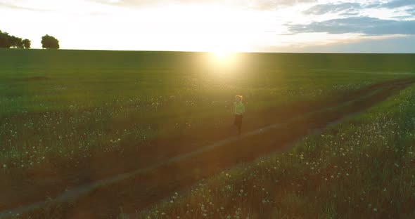 Sporty Child Runs Through a Green Wheat Field