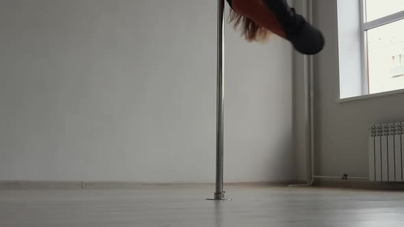 Flexible Woman Dancing on Pole in Studio