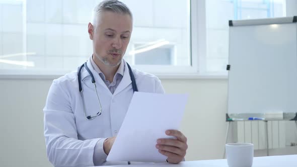 Sad Doctor Reading Medical Report of Patient