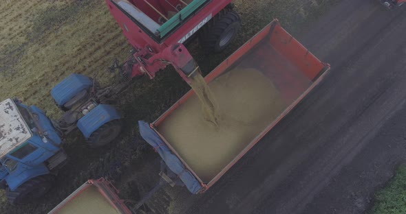 Aerial of a combine unloading grain into truck trailer