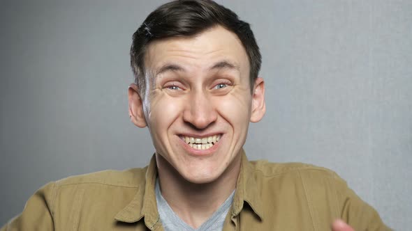 Amazed Man Shocked and Surprised to Camera Over Grey Background