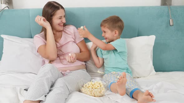 SLow Motion of Happy Laughign Family in Pajamas Having Fight with Popcorn While Watching Cartoons in